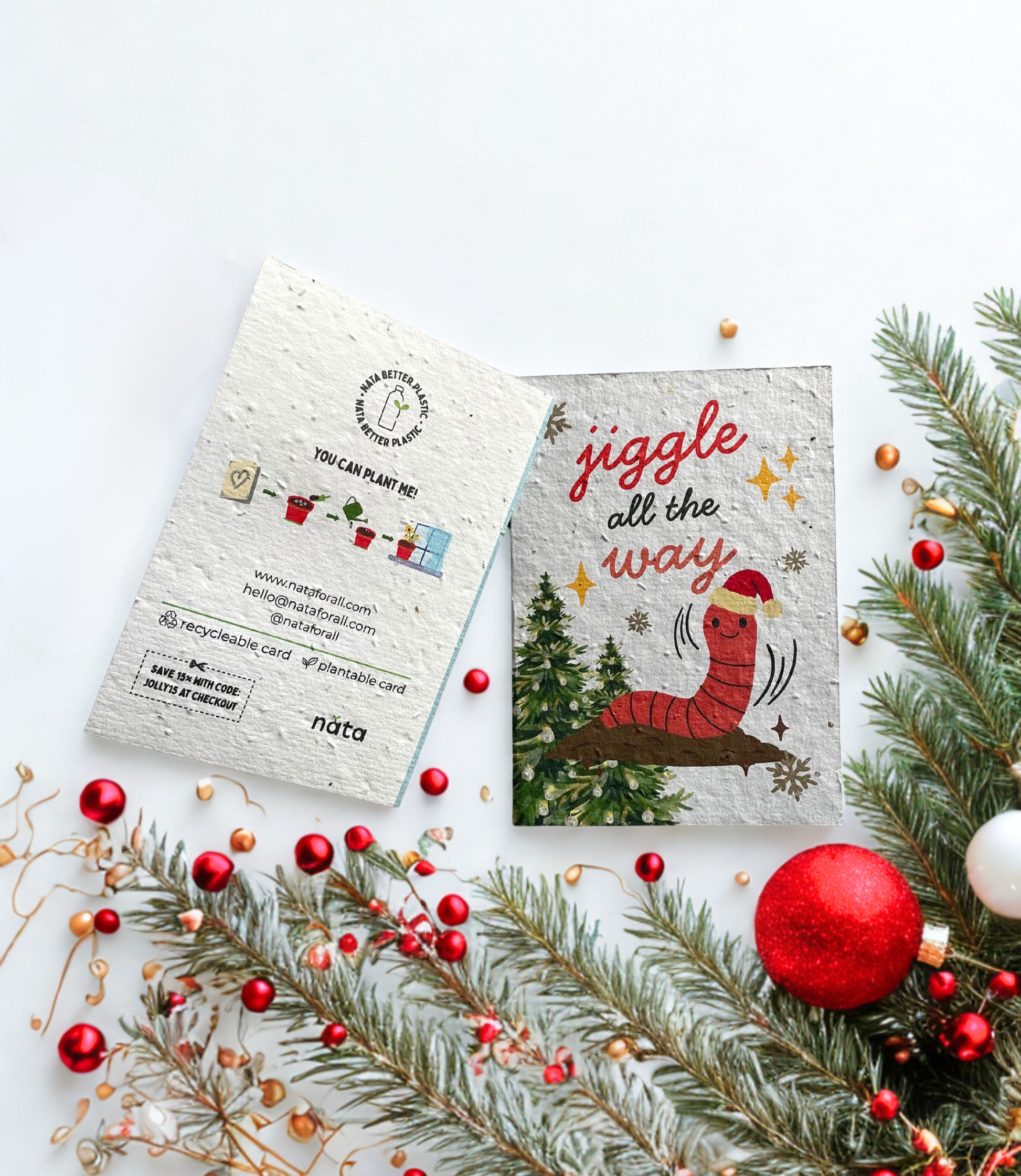 Christmas-themed seed paper card with a worm illustration and festive decorations on a white background.